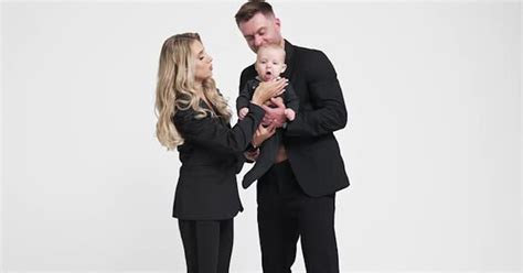 megafilm person n2|Caucasian couple wearing black suits hold their infant son. Loving .